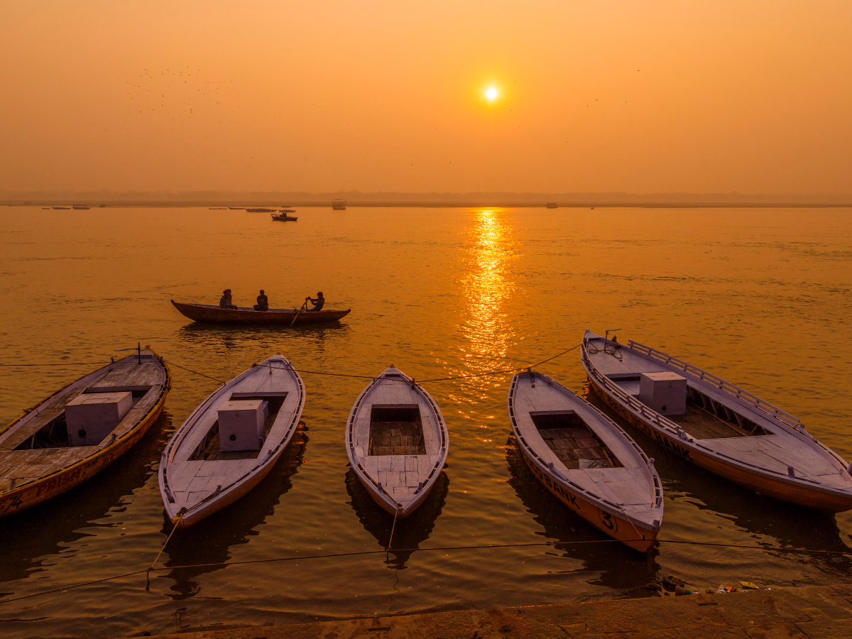 A boat moving along the Ganges at dawn in India